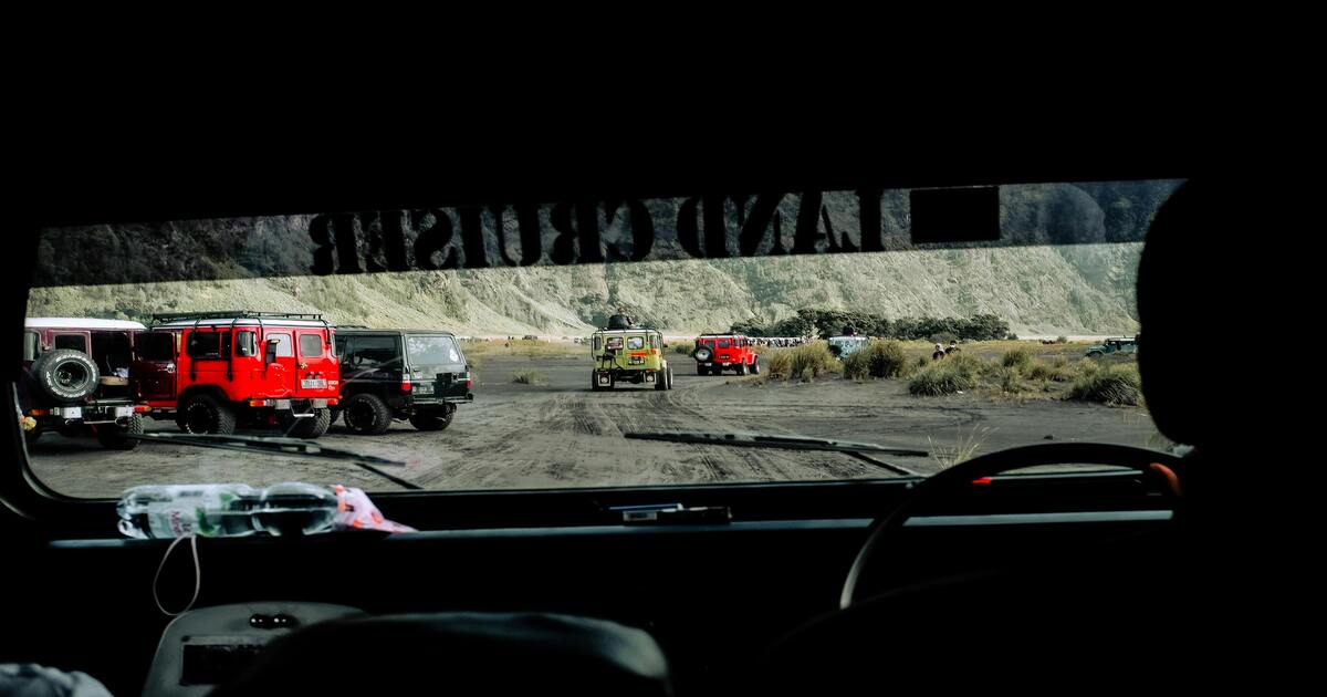 A view of off-road vehicles from the driver's seat of another vehicle.