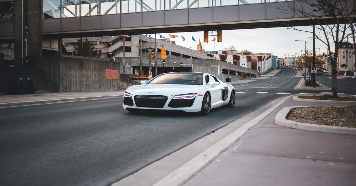 A white car driving on a road.