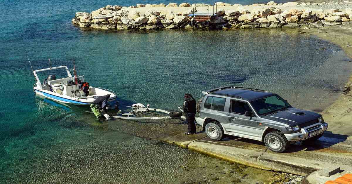 An off-road vehicle preparing to tow a boat out of water.