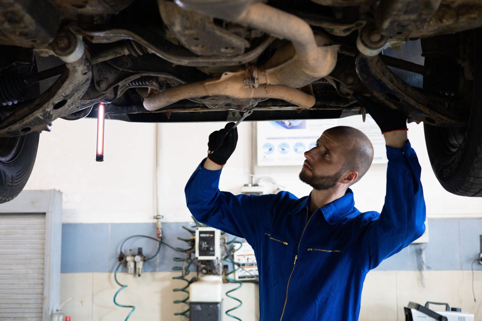 A mechanic checking the suspension system of a car.