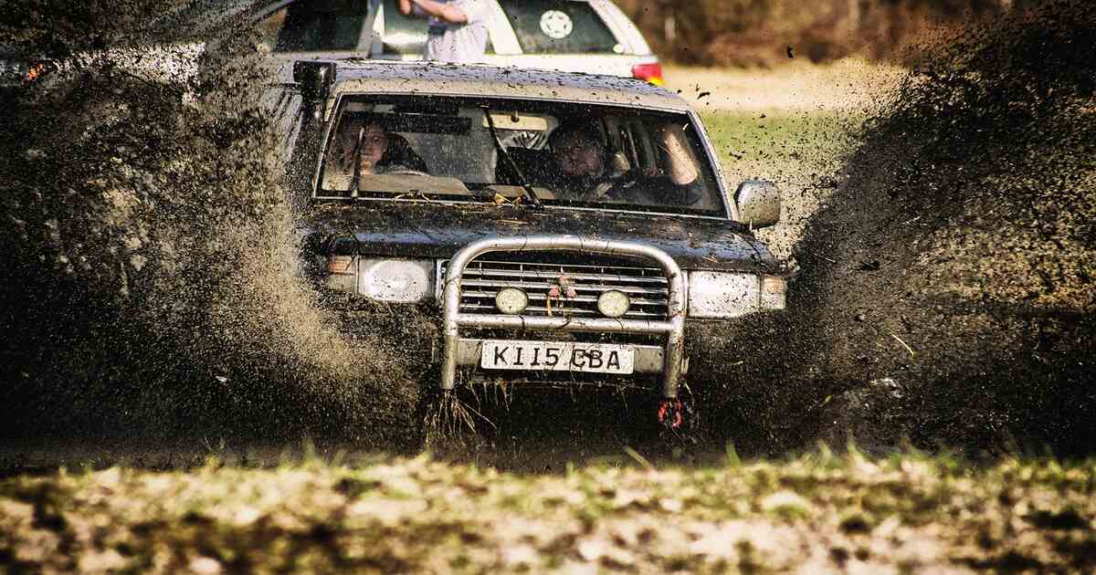 A vehicle with a snorkel crossing flowing water.