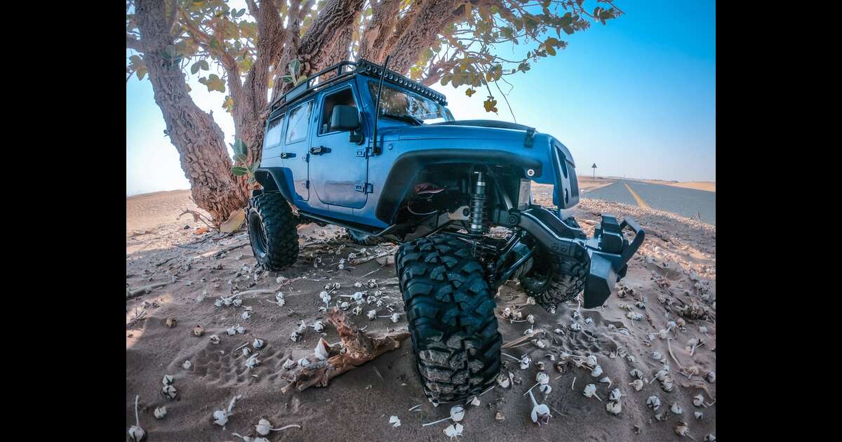 A blue jeep on a dirt road.