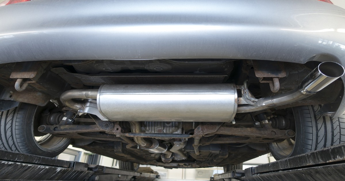 A car lifted on jack stands in order to show what a muffler does.